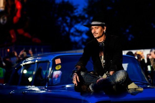 Actor Johnny Depp poses on a Cadillac at Worthy Farm in Somerset during the Glastonbury Festival