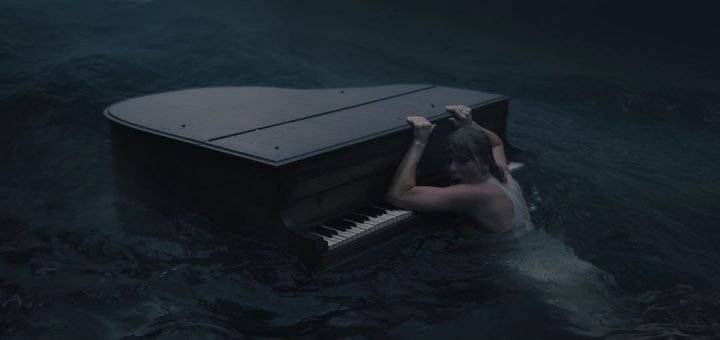 Тейлор Свифт в воде рядом с роялем, кадр из более раннего видеоклипа